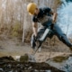 Man using a jackhammer in front of a wire fence